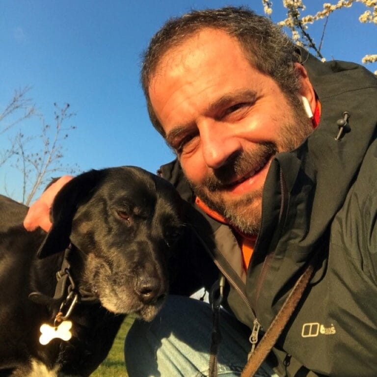 Fede smiling at camera with his dog.