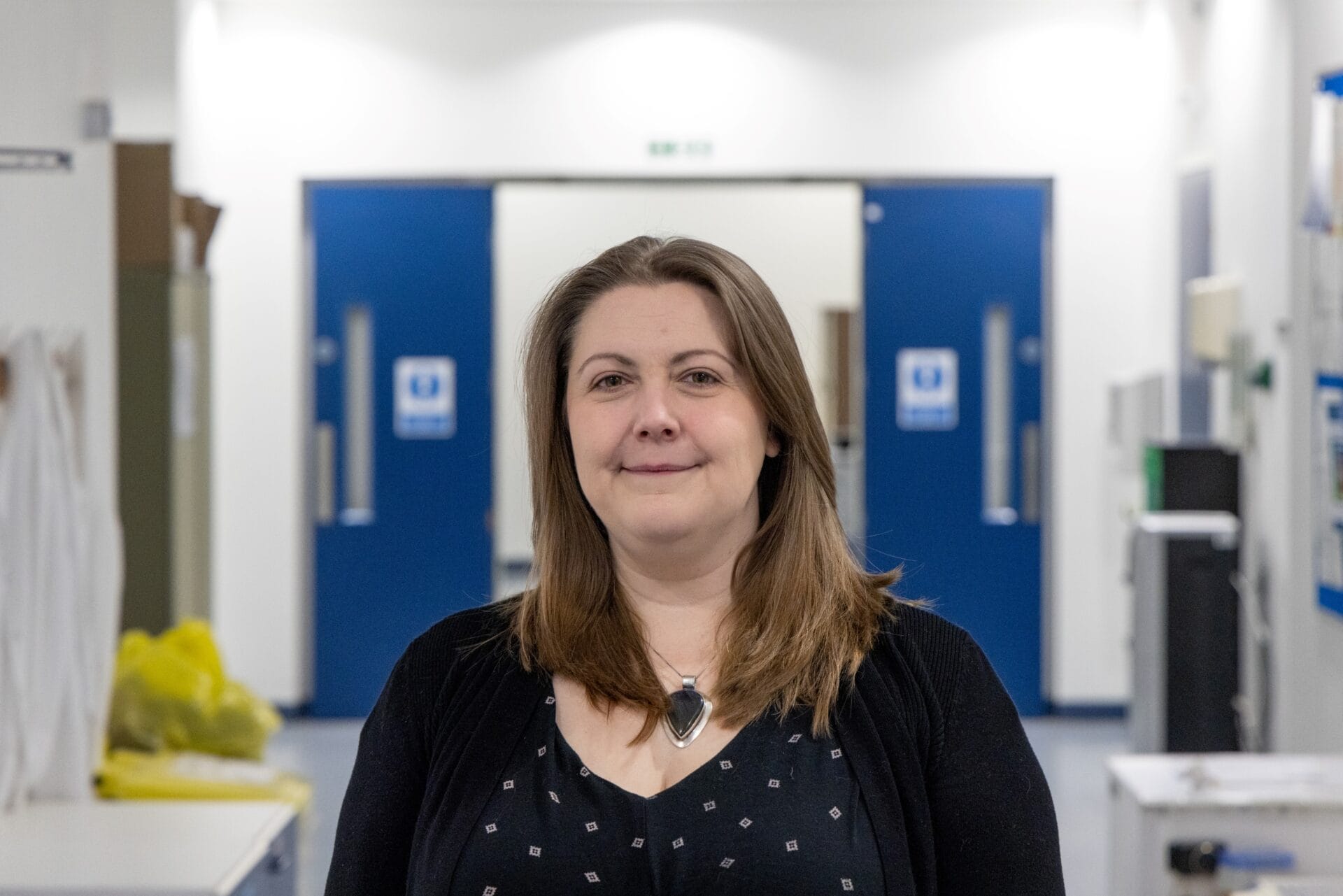 Image of Victoria smiling in the corridor of the Wellcome Sanger Institute.