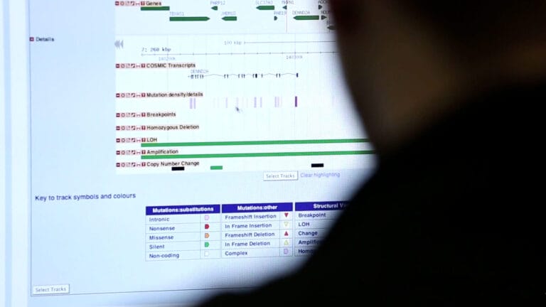 Image of a researcher looking at a computer with genomic information showing.